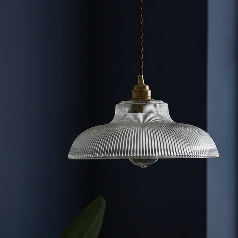 Clear ribbed glass dome pendant light with brass cap and visible bulb socket