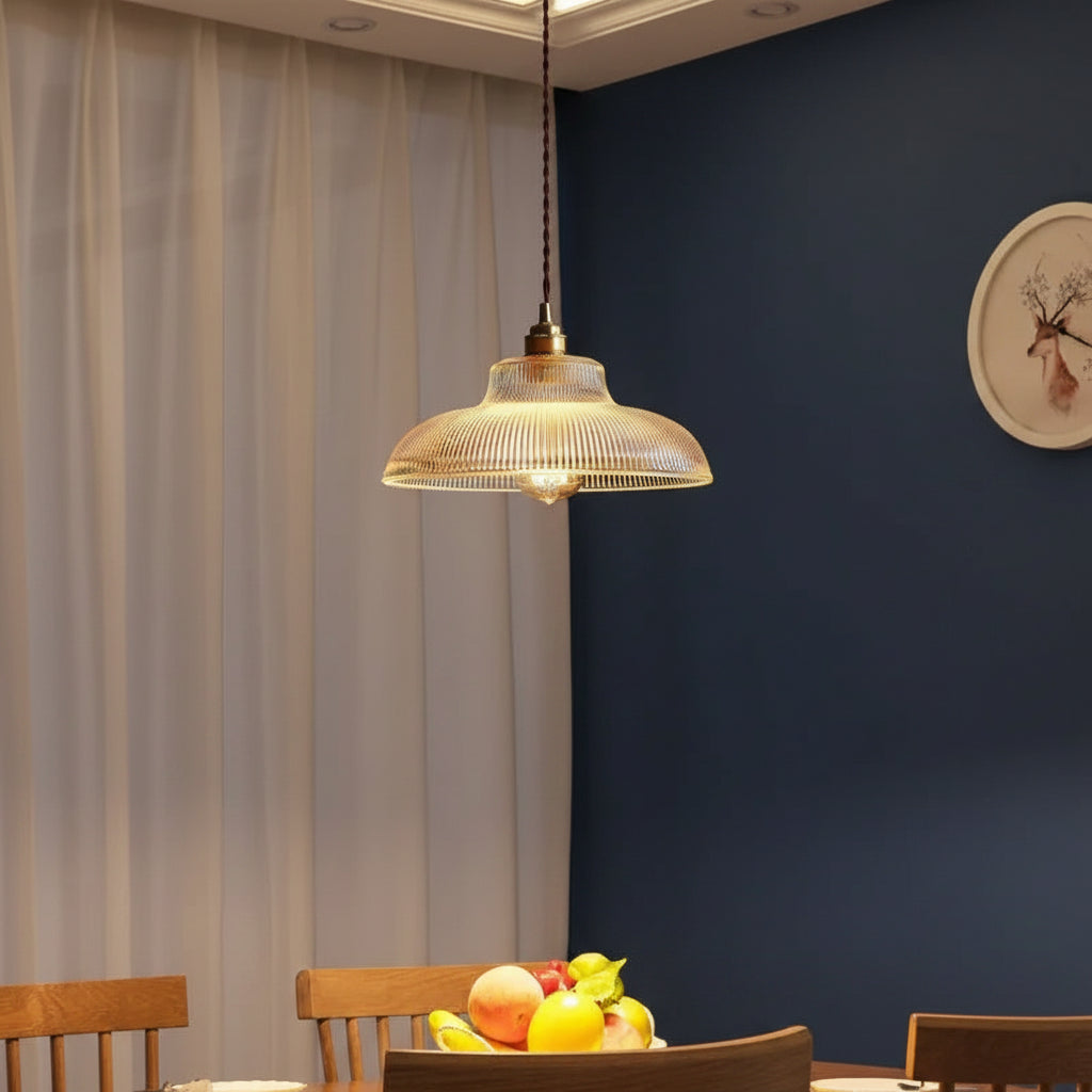 Clear ribbed glass dome pendant light hanging from a brass ceiling mount