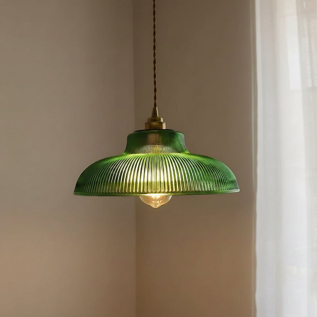 Green ribbed glass dome pendant light with brass cap and warm-lit bulb
