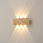 Rectangular travertine up-and-down wall sconce emitting warm light