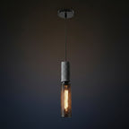 Tubular cage pendant light with dark speckled cylinder housing and warm glowing filament bulb