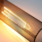Tubular metal cage around warm glowing filament bulb, with fine mesh grid detail