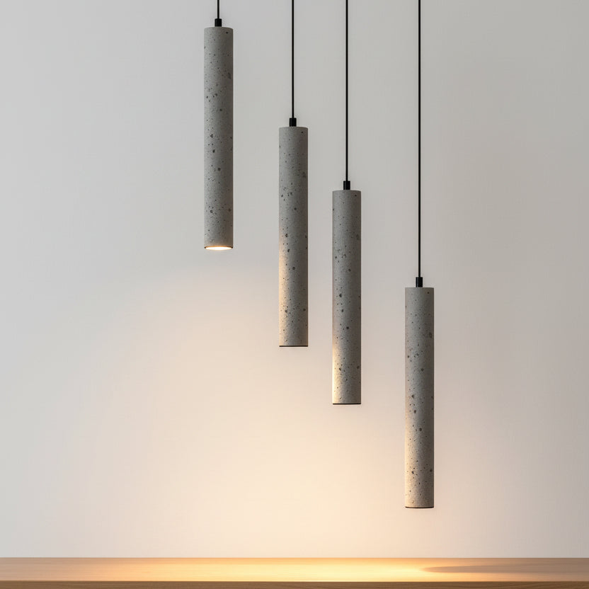Set of tubular pendant lights with speckled gray concrete shades and black cords