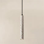 Speckled white cylindrical pendant light with black cord and open top.