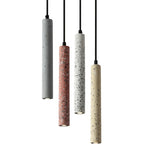 Set of speckled cylindrical pendant lights in gray, red, and cream with black cords.