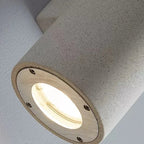 Recessed faceplate of a concrete wall light with circular opening and screws