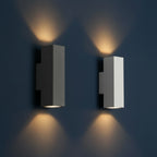 Two concrete wall lights with cylindrical shades, sand white and dark finishes