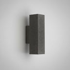 Concrete wall light with cylindrical shade, dark speckled finish and square mounting backplate