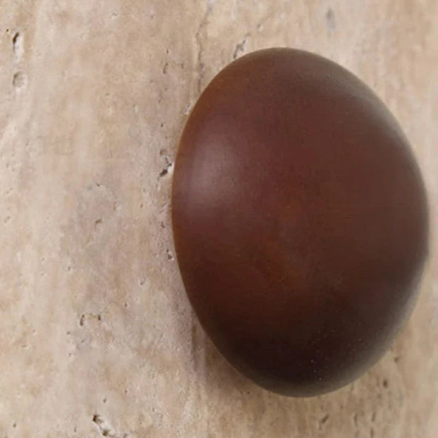 Close-up of dark circular lens on textured round backlit wall sconce