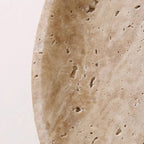Close-up of textured tan stone disc on a round backlit wall sconce
