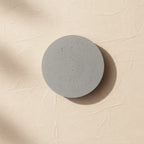 Round concrete wall light with speckled light-gray face