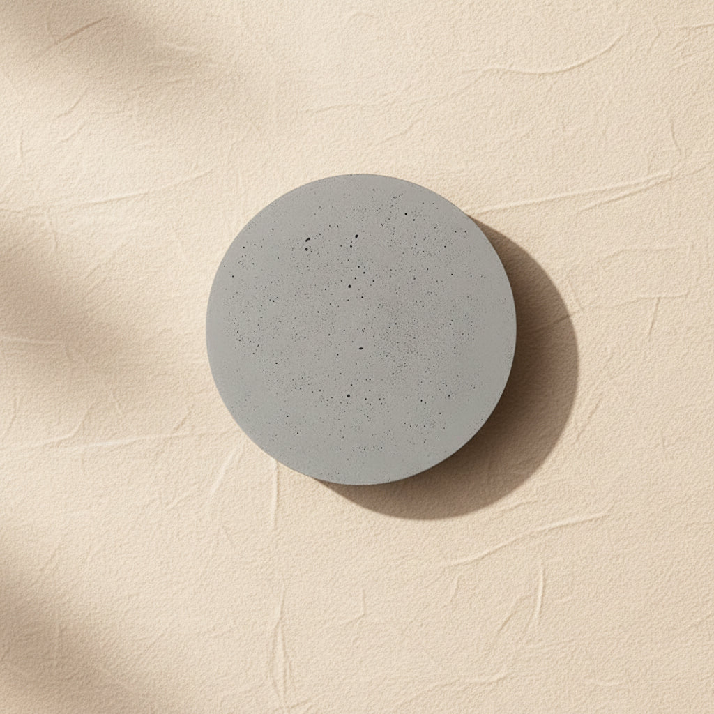 Round concrete wall light with speckled light-gray face