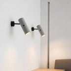 Wall-mounted set of three tubular rotatable lights, grey speckled cylinders, black mounts