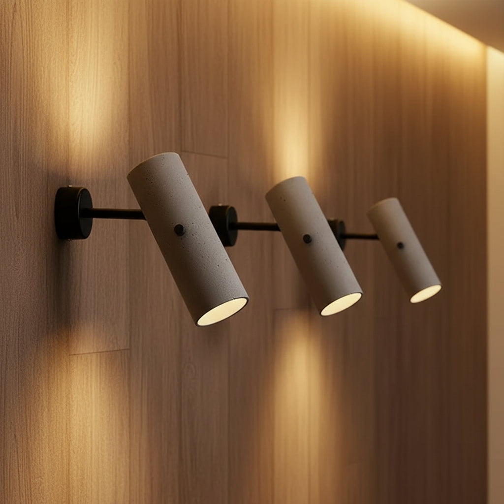Set of rotatable tubular wall lights, grey speckled cylinders with black mounts, downlight