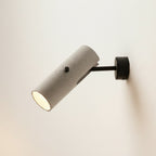 Rotatable tubular wall light with grey speckled cylinder, black round backplate, downlight