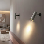 Wall-mounted rotatable tubular light with grey speckled cylinder, black arm, glowing downlight