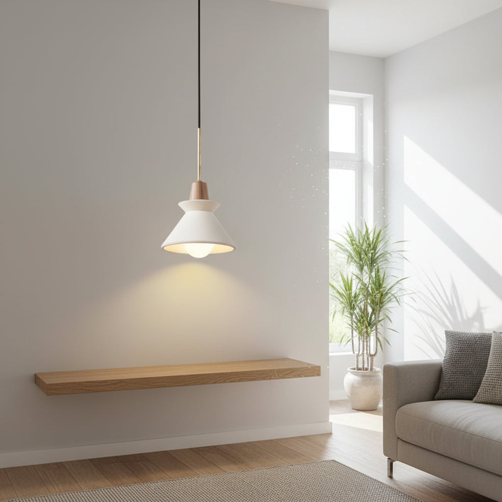 Pendant light with white cone shade and gray concrete canopy hanging from brass cord