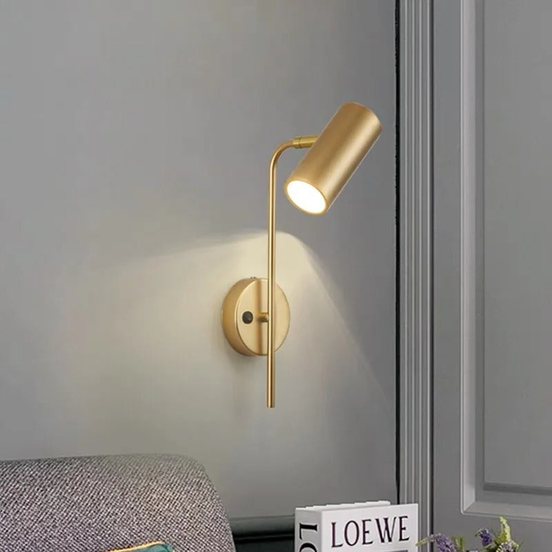 Gold swivel head wall spotlight with lit cylindrical shade