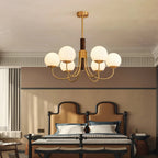 Multi-arm globe chandelier with warm brass finish and frosted white glass shades