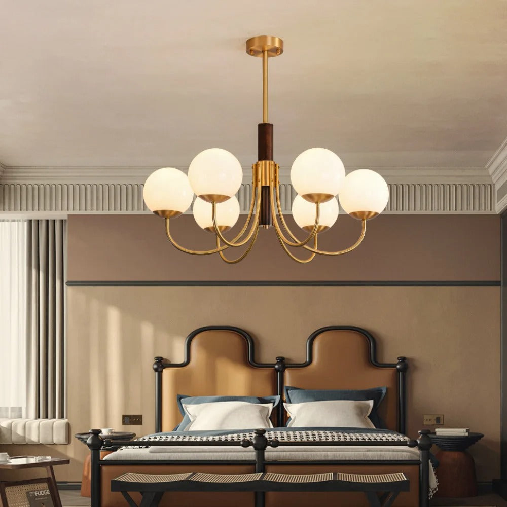 Multi-arm globe chandelier with warm brass finish and frosted white glass shades