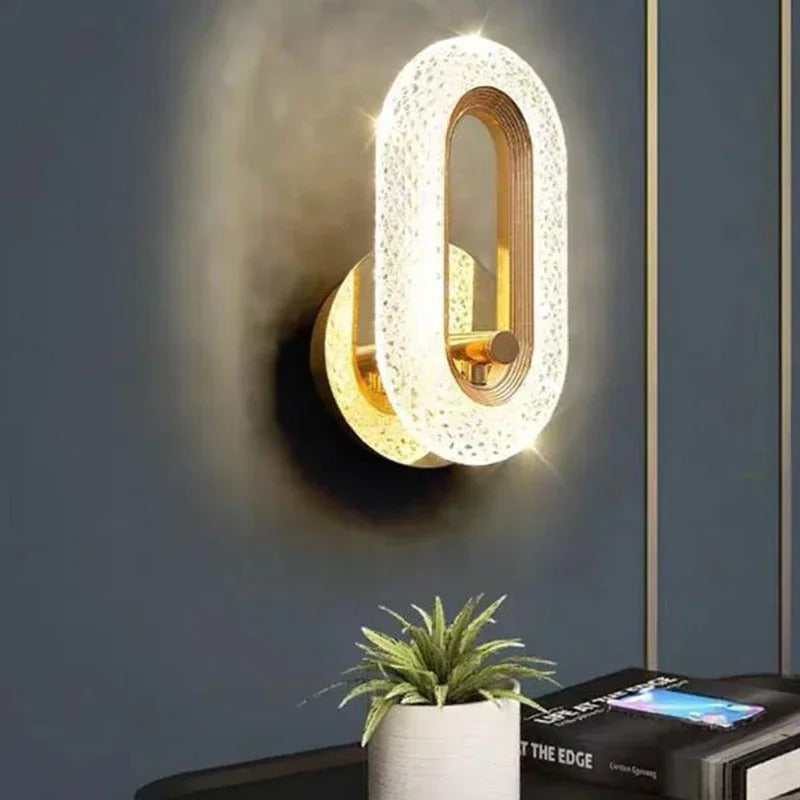 Gold textured oval wall light with bright illuminated center and glowing halo