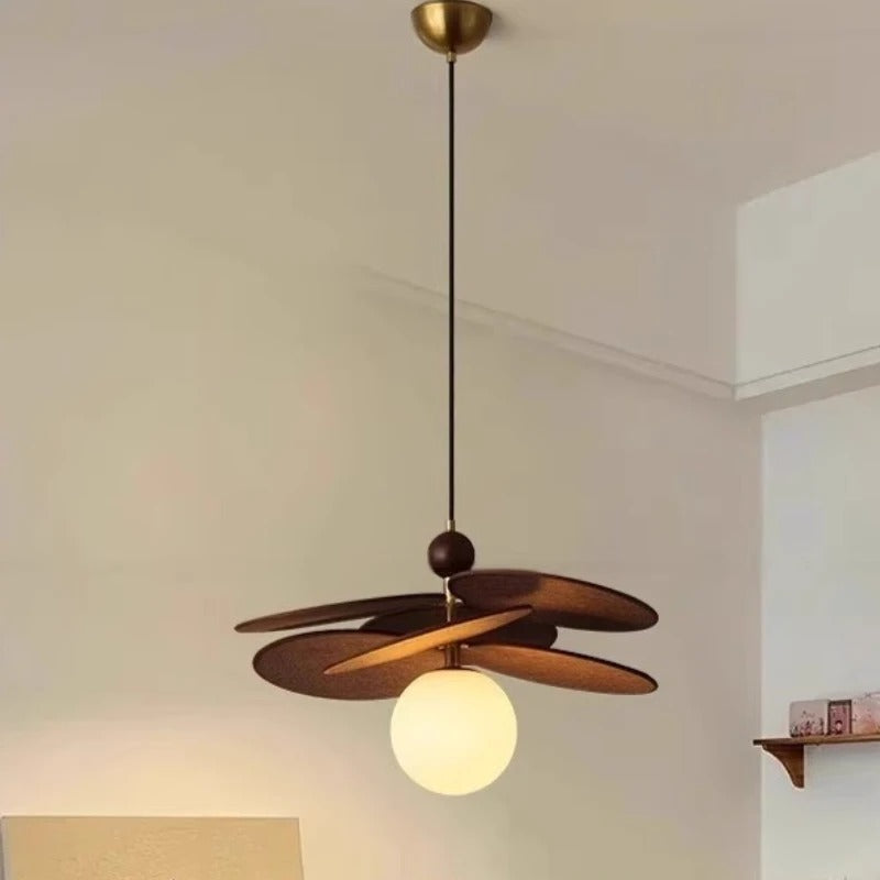 Opal globe pendant light with brass stem, dark fan arms, and glowing opal globe