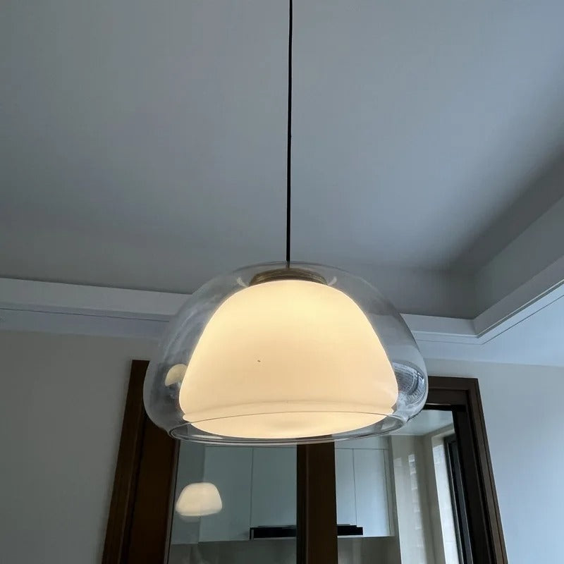 Nordic tinted glass pendant light with clear glass dome and soft warm glow