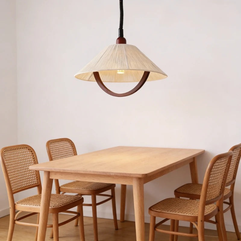 Cone linen pendant light with warm interior glow, dark brown ring, and black cord