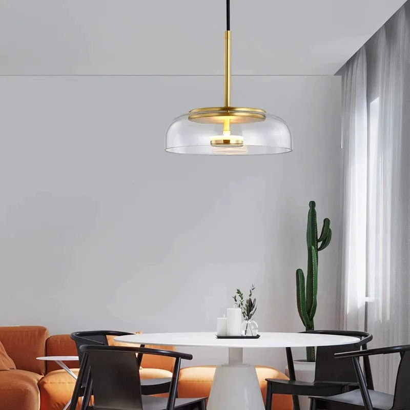 Dome glass pendant light with clear glass shade and gold top ring, warm bulb on