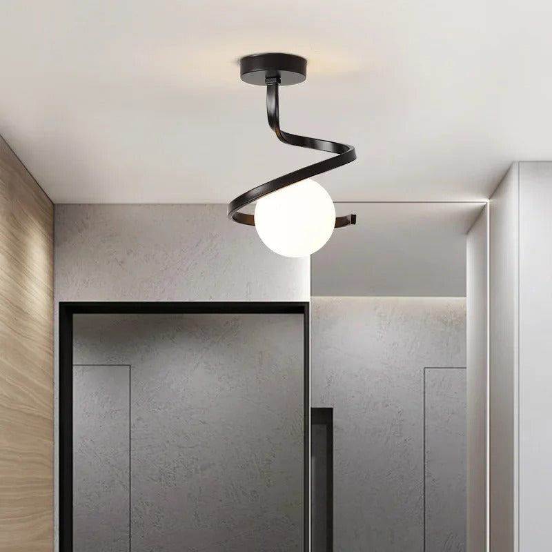 Black spiral ceiling light with one white globe shade and angled mounting canopy.
