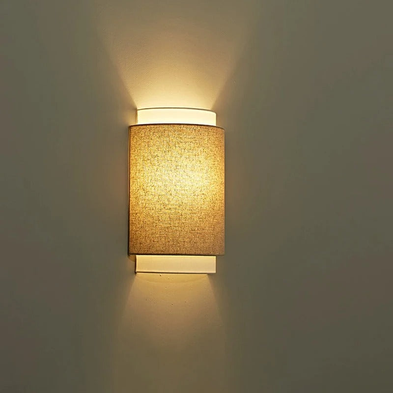 Warm-lit beige fabric D-shaped wall light, soft glow through fabric shade