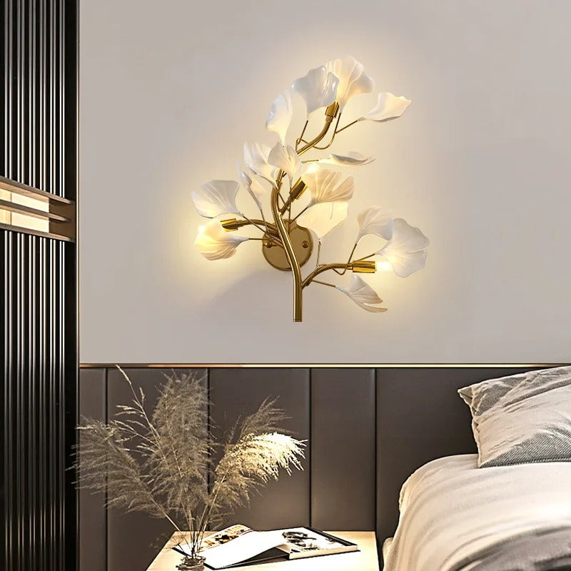 Ginkgo leaf wall sconce mounted on wall with warm glowing off-white leaf shades