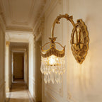 Gold crystal wall sconce with curved mount and one hanging glass shade cluster