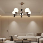 Multi-arm globe chandelier with five white glass shades and black finial accents