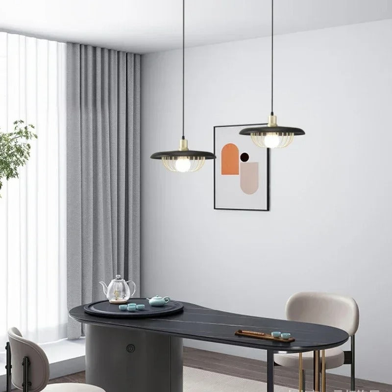 Set of two wire-cage saucer pendant lights with dark disc shades and visible bulbs