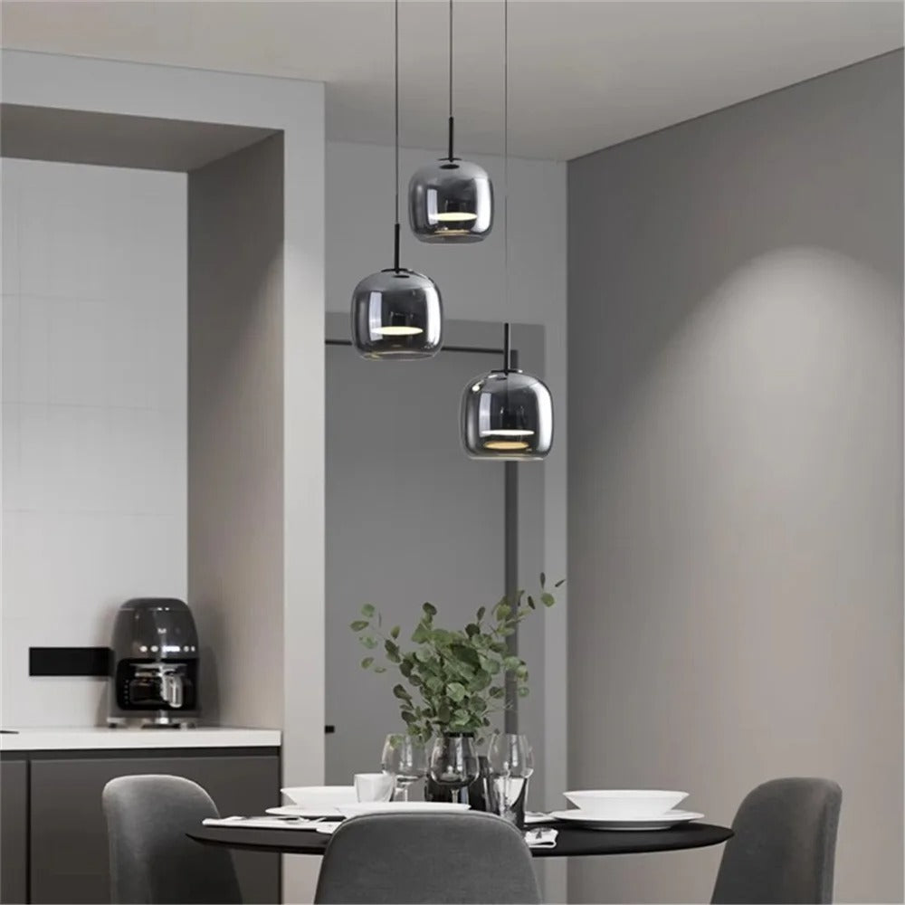 Smoked glass cube pendant lights over dining table, multiple black cords