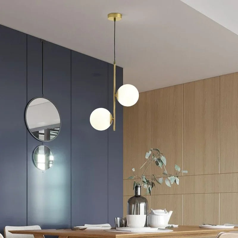 Gold globe pendant light with three white glass shades