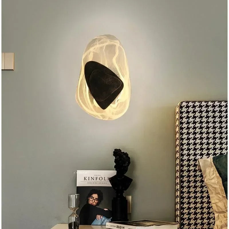 Layered egg wall light with glowing translucent shell and black center shade