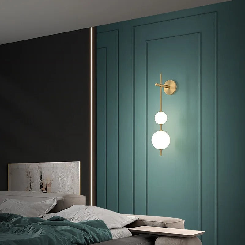 Gold wall sconce with two stacked white globe shades