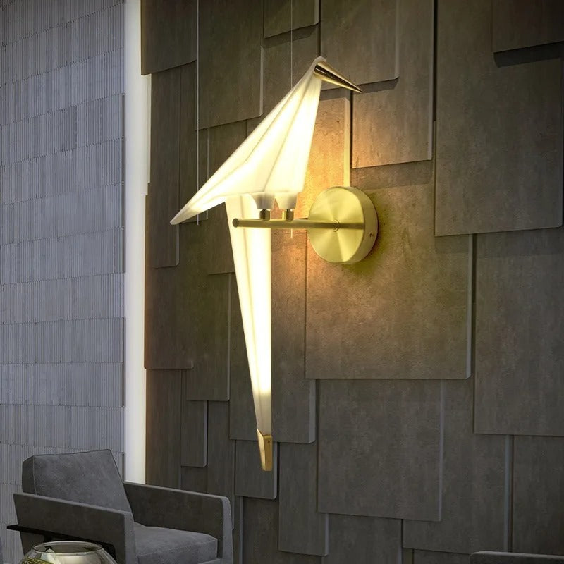 Wall-mounted gold bird wall light with paper origami shade, glow on
