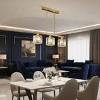 Gold linear chandelier with five clear cylindrical glass shades and vertical rods