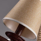 Fabric drum lamp shade with light beige exterior and gray trim on chandelier