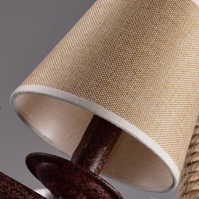 Fabric drum lamp shade with light beige exterior and gray trim on chandelier