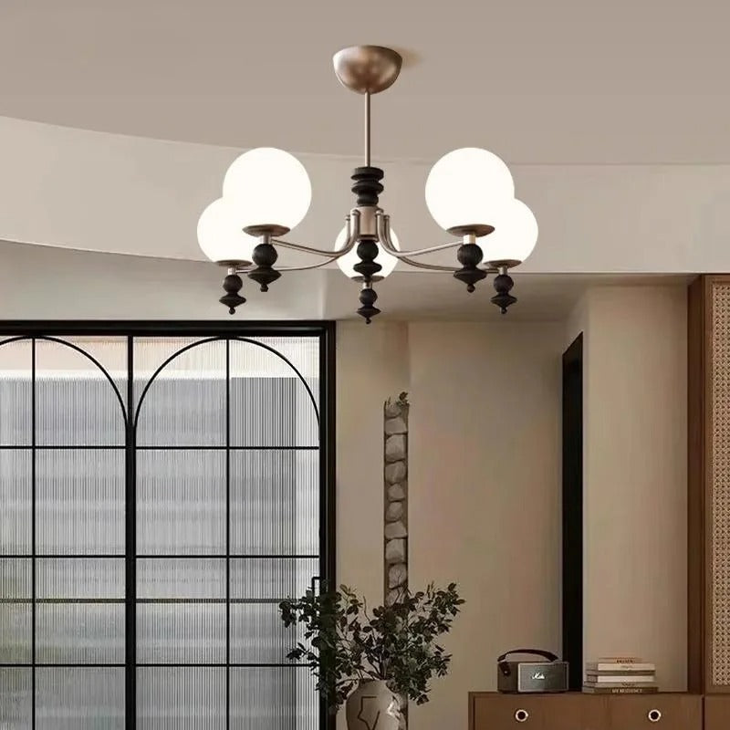 Bronze multi-arm globe chandelier with multiple round white glass shades and central hub