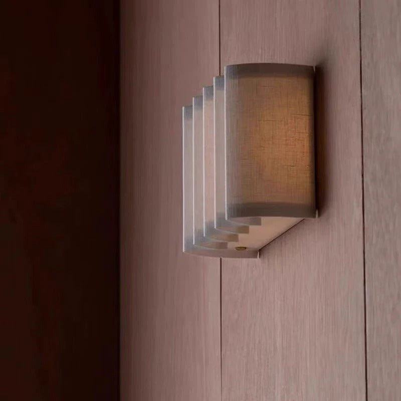 Rectangular wall light fixture with tiered slatted back and linen shade