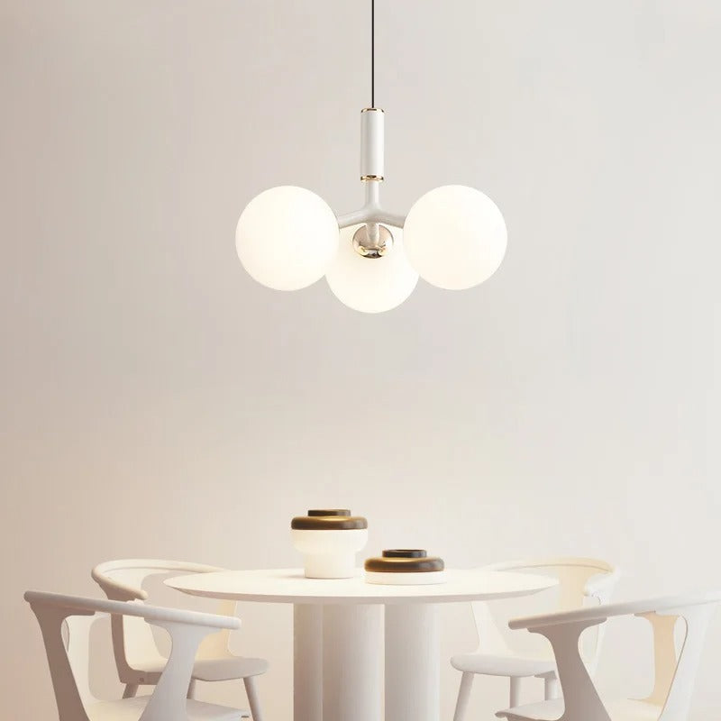 White globe pendant light with three round glass shades on a central bar