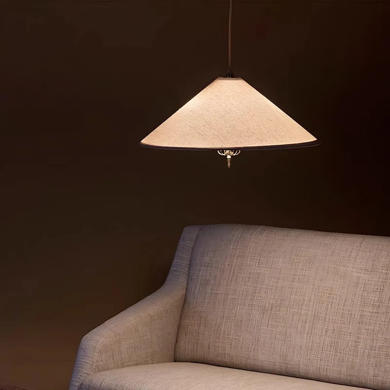 Cone pendant light with beige fabric shade and brass finial details