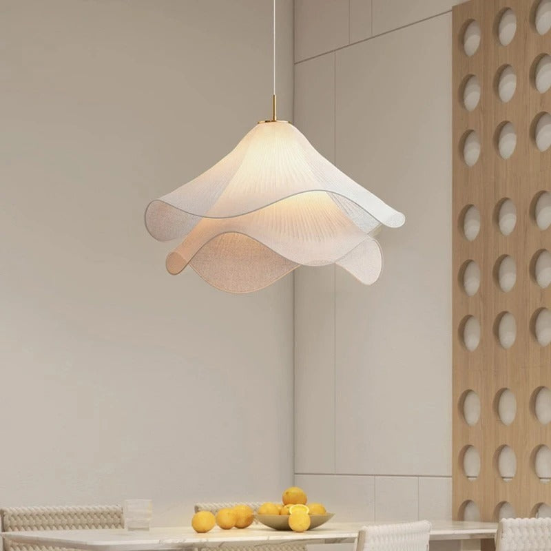 Off-white fabric flower pendant light hanging above table in a modern room