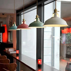 Cluster of vintage barn pendant lights with green, white, and yellow metal shades