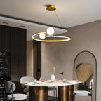 Gold ring LED chandelier with three white globe lights over a dining table